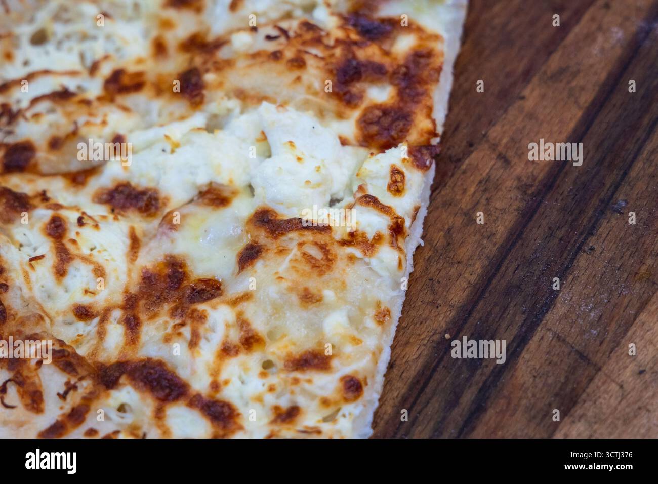 Nahaufnahme von Gyuzleme-Teig gefüllt mit Quark auf einem Holztisch Stockfoto