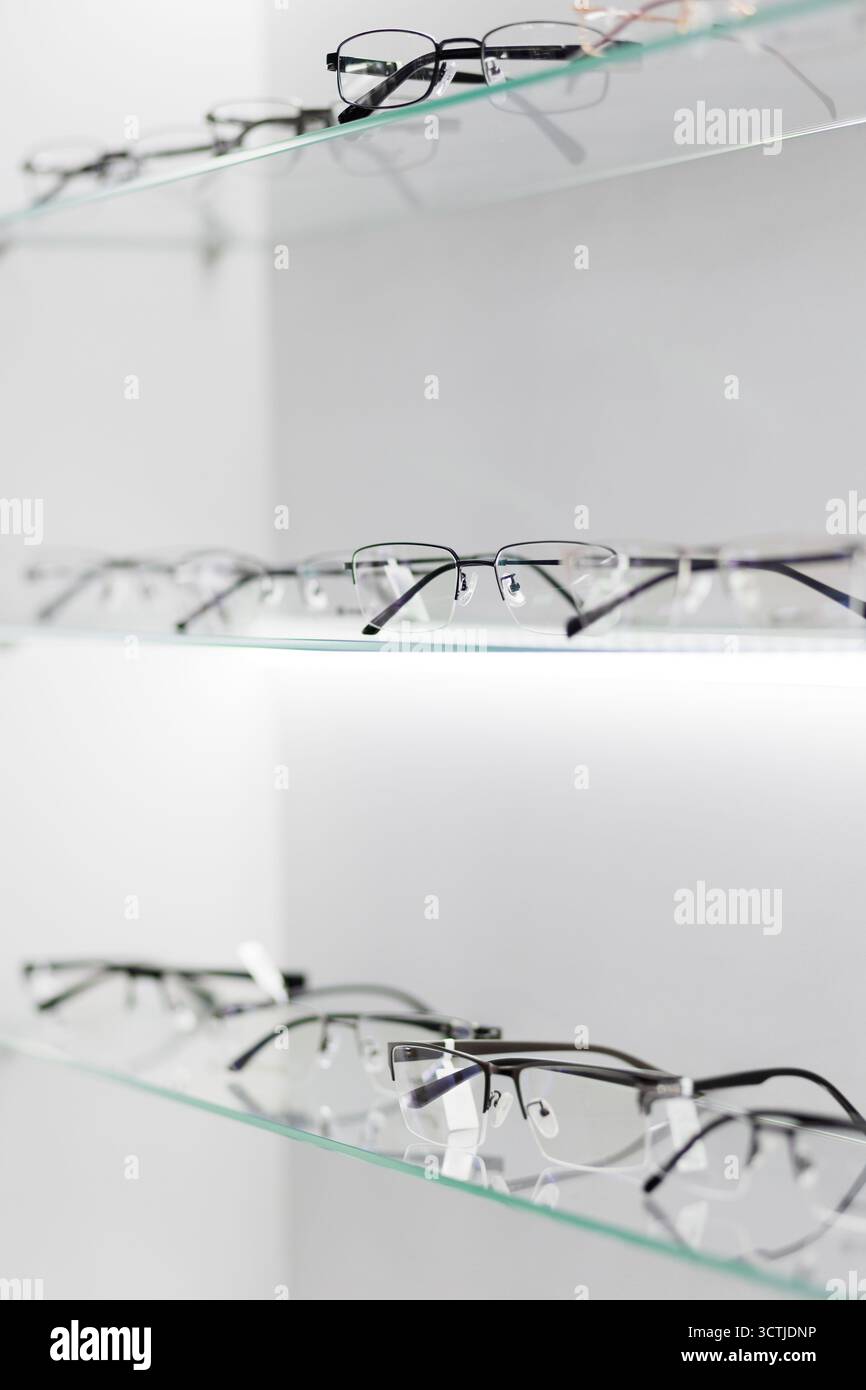 In den Regalen finden Sie eine vielfältige Brillenkollektion in einem schicken Optikgeschäft, in dem Sie Ihre Kunden dazu einladen, die Optionen für stilvolle Brillen zu erkunden. Stockfoto