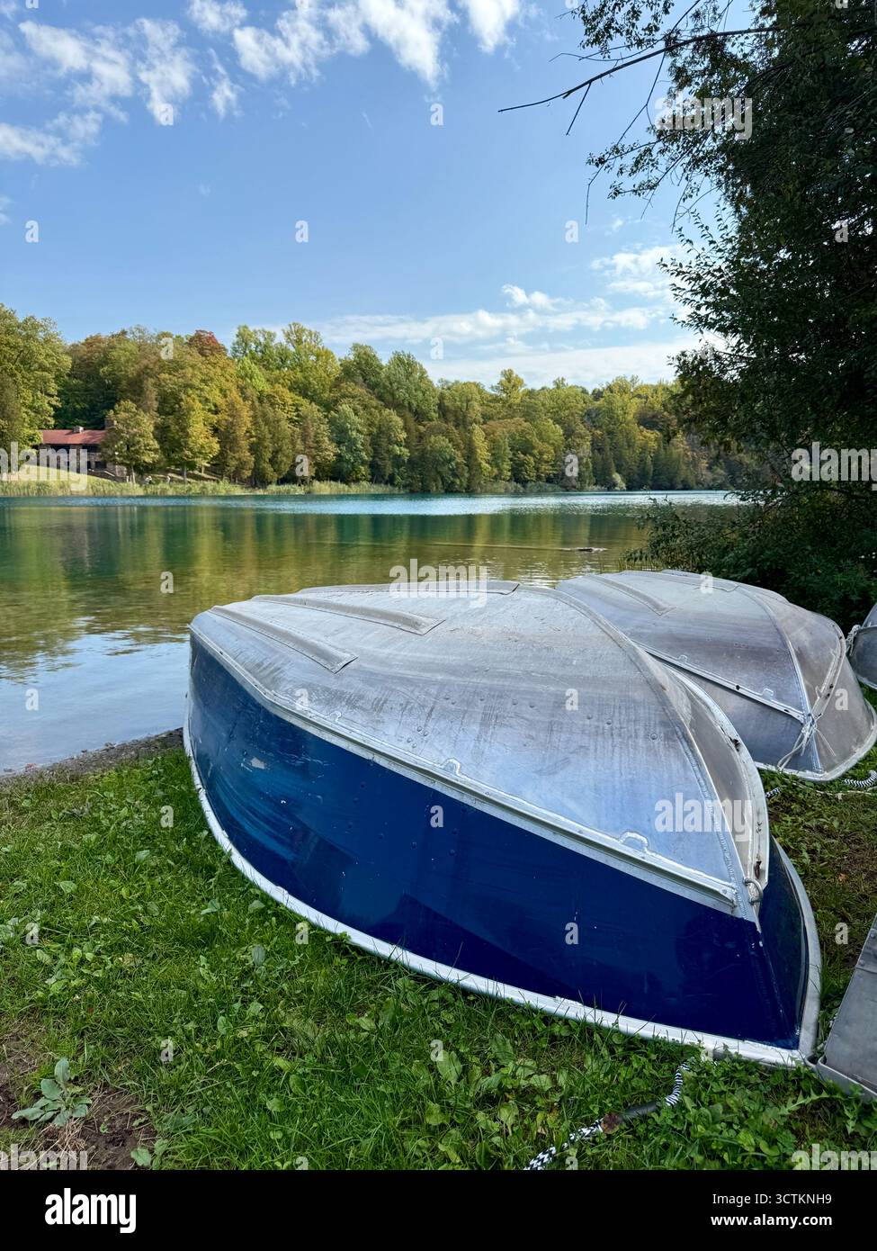 Wunderschöne Herbstszene mit Ruderbooten im Vordergrund. An einem sonnigen Tag mit Bäumen und Wasser im Hintergrund. Stockfoto