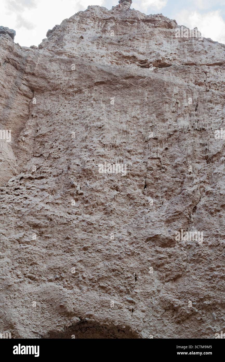 Eine Klippenwand im Natural Bridge Canyon, Death Valley, mit getrockneten Schlammtropfen, die an irdische Eiszapfen in skulpturiertem Wüstengelände erinnern. Stockfoto