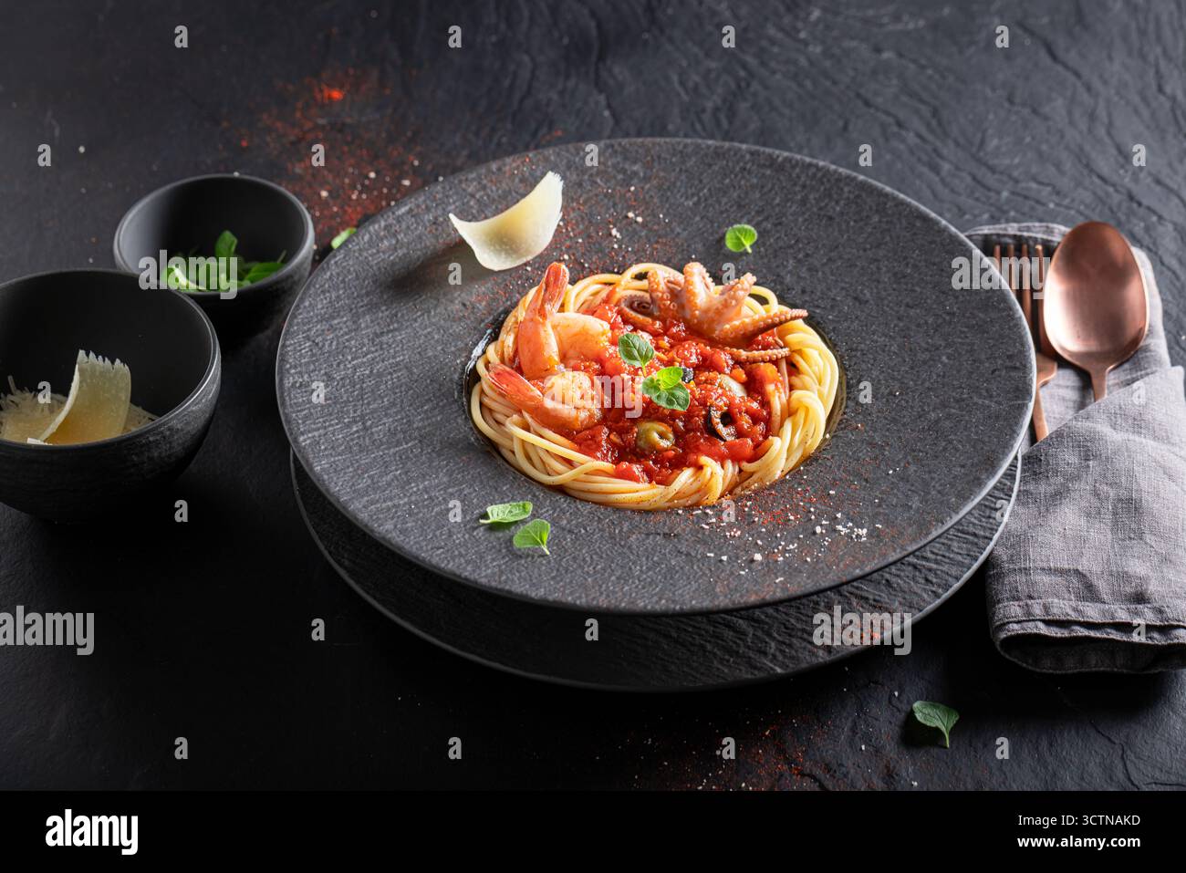 Elegante Spaghetti-Bolognese mit Tomaten, Olivenöl und Meeresfrüchten. Spaghetti Bolognese mit exquisiter Dekoration. Stockfoto