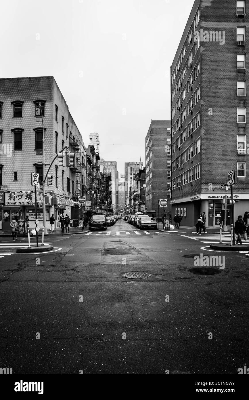 Schwarzweiß-Foto einer städtischen Straße mit hohen Gebäuden. Stockfoto