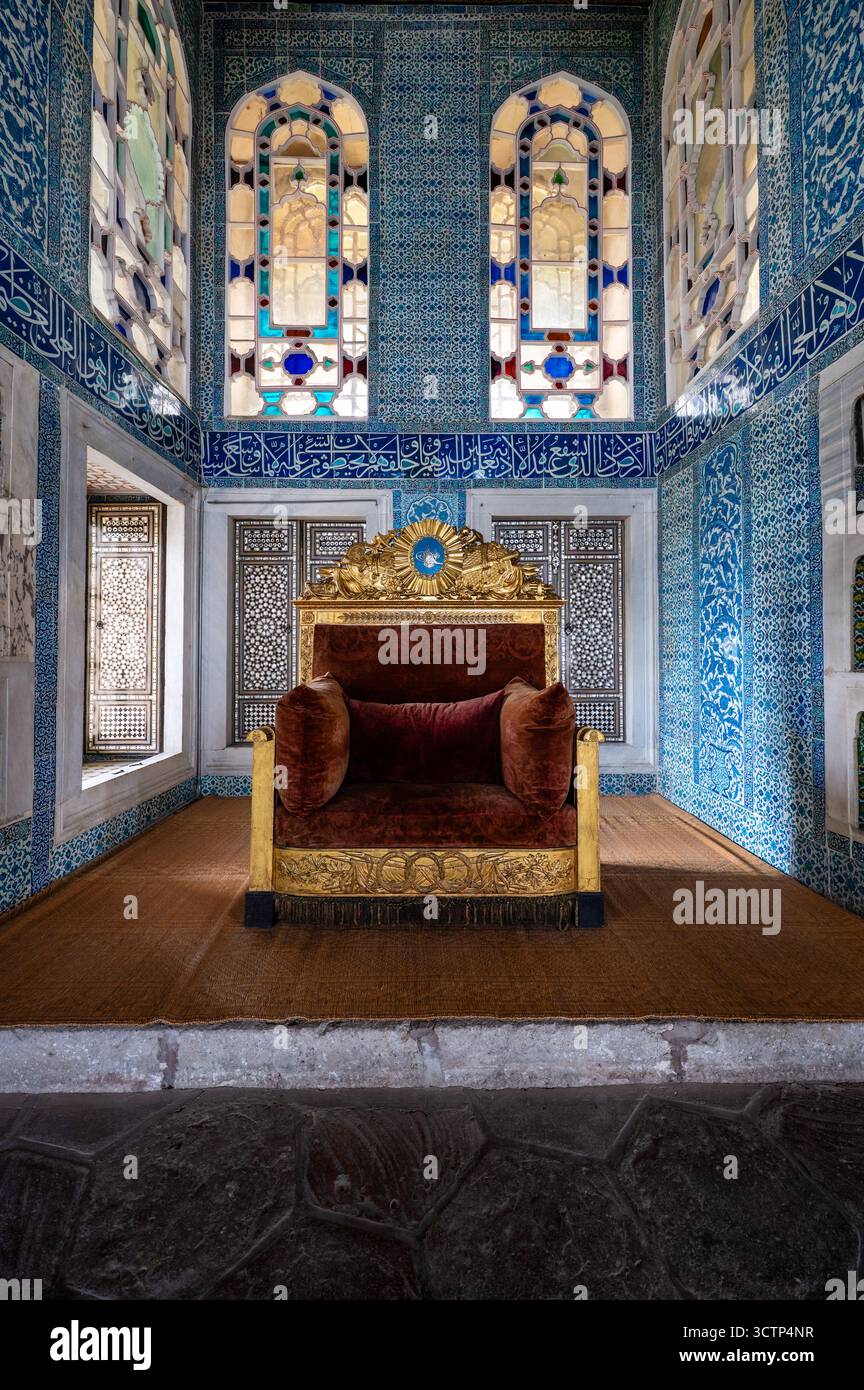 Ein goldener osmanischer Thron sitzt in einem reich dekorierten, blau gefliesten Raum im Topkapi-Palast in Istanbul, Türkei Stockfoto