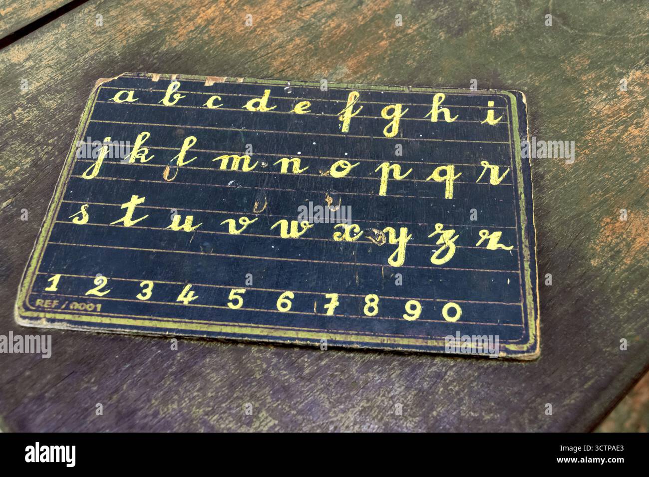 Eine kleine Tafel mit dem Alphabet liegt auf dem Schulpult. Stockfoto