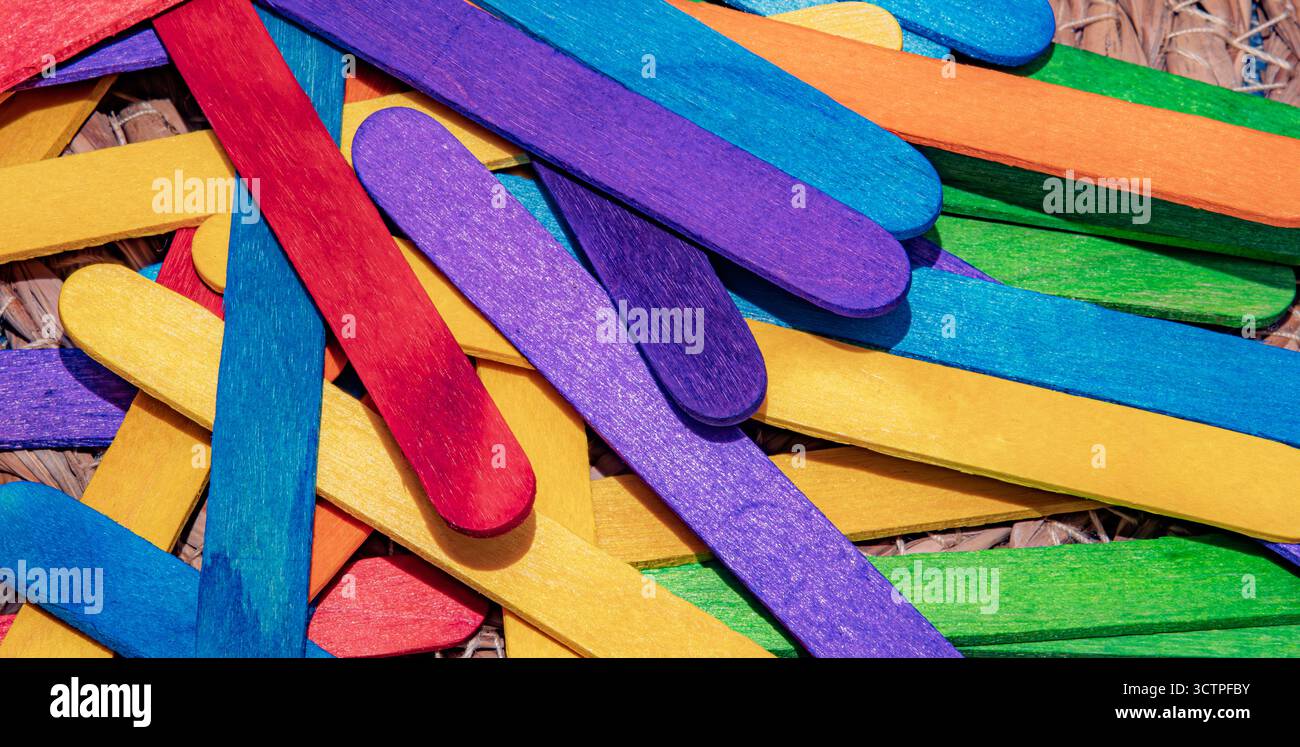 Haufen bunter Holzstöcke in Rot, Blau, Grün, Gelb, Orange und Lila. Diese Bastelstöcke werden für Kunstprojekte verwendet. DIY-Kreationen oder verspielt Stockfoto