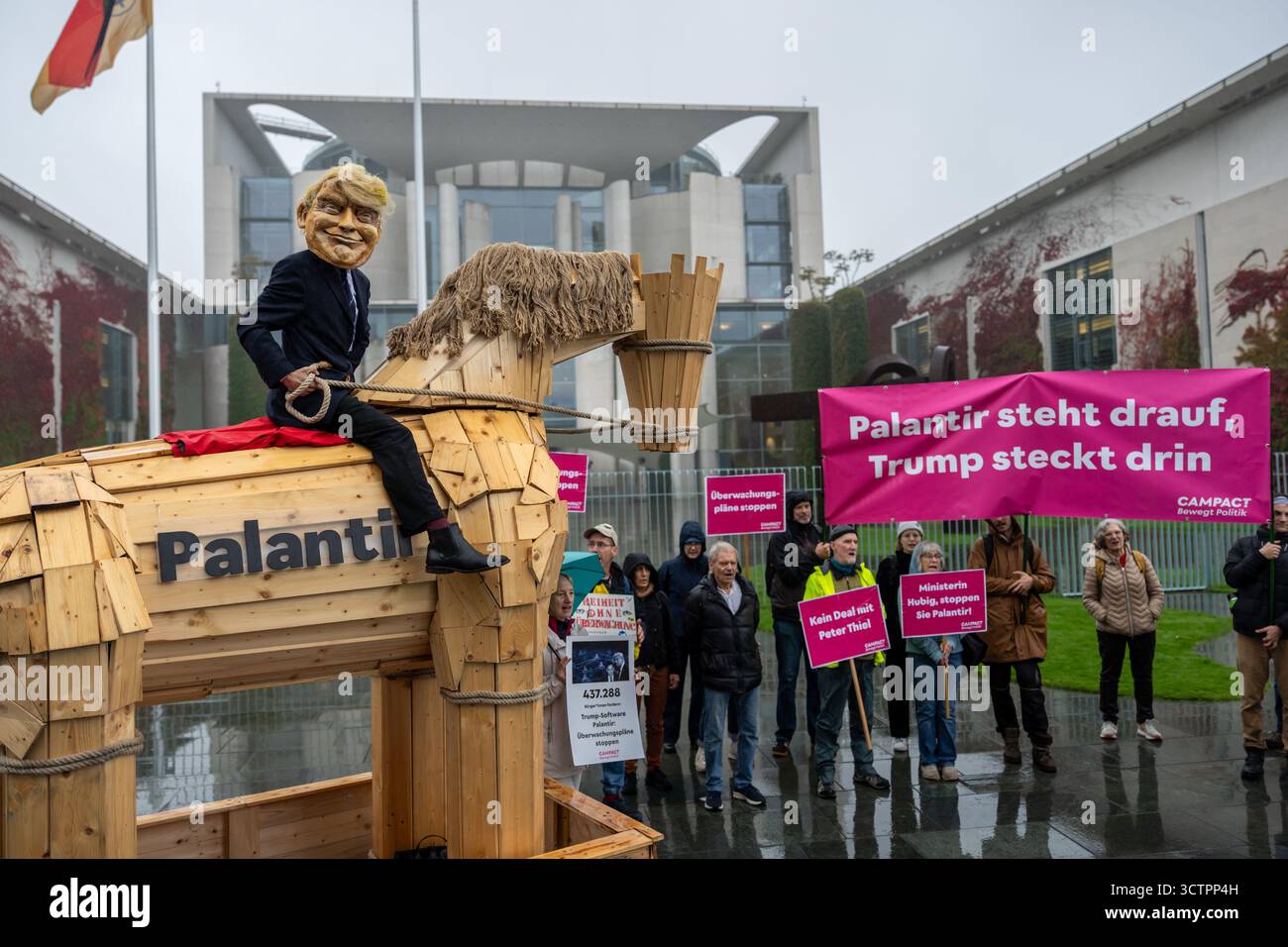 Berlin, Deutschland. Oktober 2025. Aktivisten der Kampagnenorganisation Campact stehen vor der Kanzlei mit einem Trojanischen Pferd mit dem Logo „Palantir“, um gegen die Einführung der US-Software Palantir in der Polizei zu demonstrieren. Quelle: Michael Kappeler/dpa/Alamy Live News Stockfoto