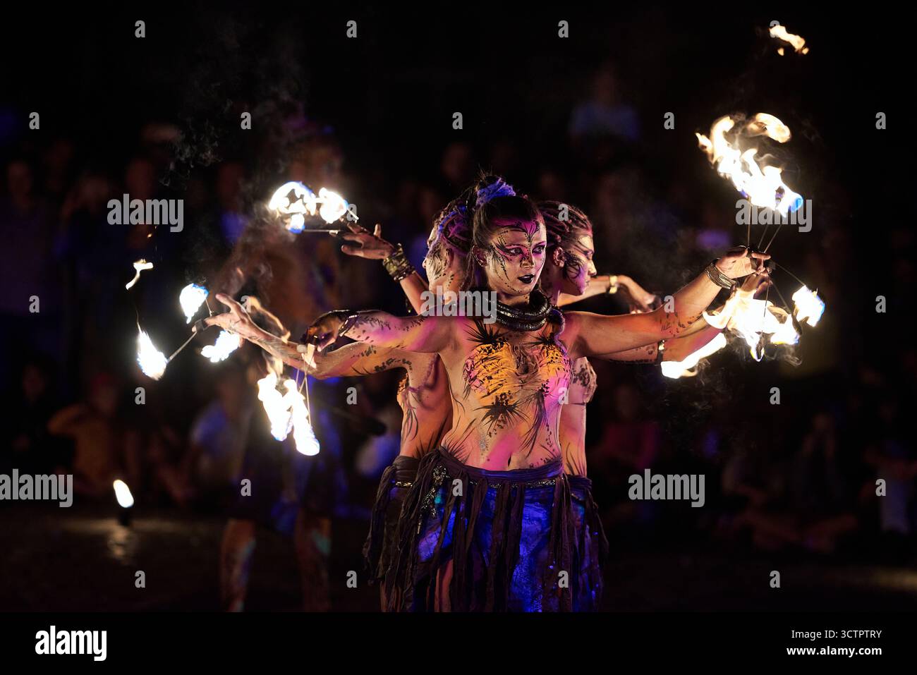 Feuertänzer führen im Los Fuegos Fire Theatre in Polen eine synchronisierte Routine mit brennenden Fackeln auf, die in dynamischen, schwachen Szenen mit stro aufgenommen wird Stockfoto
