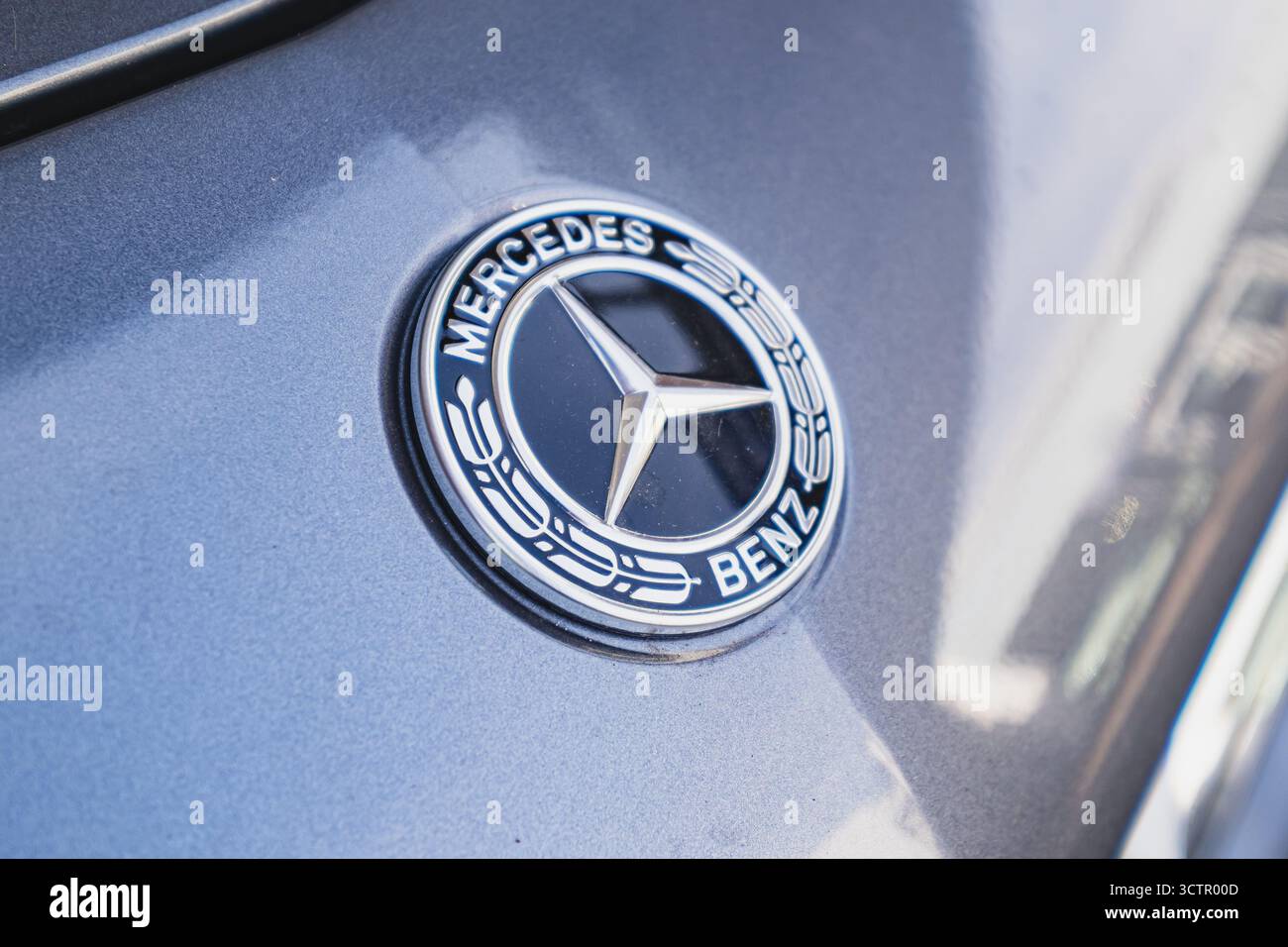 Mercedes-Benz Emblem auf der Vorderseite eines Fahrzeugs außerhalb des Händlerbetriebs Stockfoto