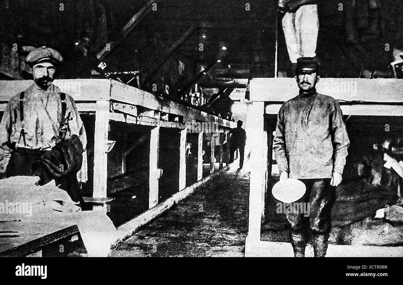 Ab Le Miroir, 30. Januar 1916. Das Innere einer deutschen Kriegsgefangenenbaracke mit engen Holzbetten, die von alliierten Gefangenen benutzt wurden. Obwohl die deutsche Propaganda die Lagerorganisation betonte, beschrieb sie schlechte Hygiene, Überfüllung und unzureichende Luftzirkulation. Das Foto zeigt die harten Bedingungen, denen Gefangene während des Ersten Weltkriegs gegenüberstanden, und spiegelt sowohl körperliche Not als auch Vernachlässigung in Kriegsgefangenenlagern wider. Stockfoto