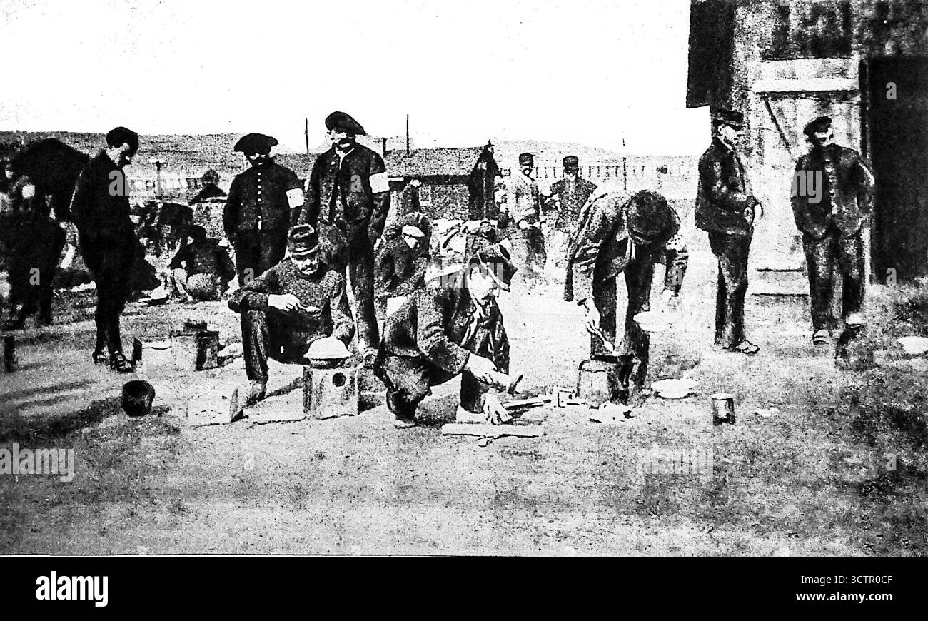 Veröffentlicht in Le Miroir, 30. Januar 1916. Alliierte Gefangene in einem deutschen Lager bereiten Mahlzeiten im Freien mit improvisierten Utensilien wie alten Keksdosen zu. Das Bild zeigt die unzureichenden Einrichtungen und das schwierige tägliche Leben, die Kriegsgefangene während des Ersten Weltkriegs ertragen mussten. Trotz der deutschen Ansprüche auf Effizienz des Lagers fand die Zubereitung von Nahrungsmitteln oft unter unhygienischen Bedingungen statt, wodurch die Gefangenen Hunger, Krankheit und Not ausgesetzt waren. Stockfoto