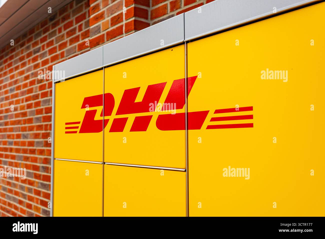 DHL-Firmenlogo auf der automatisierten Self-Service-Verpackungsstation in gelber Farbe der Marke Stockfoto