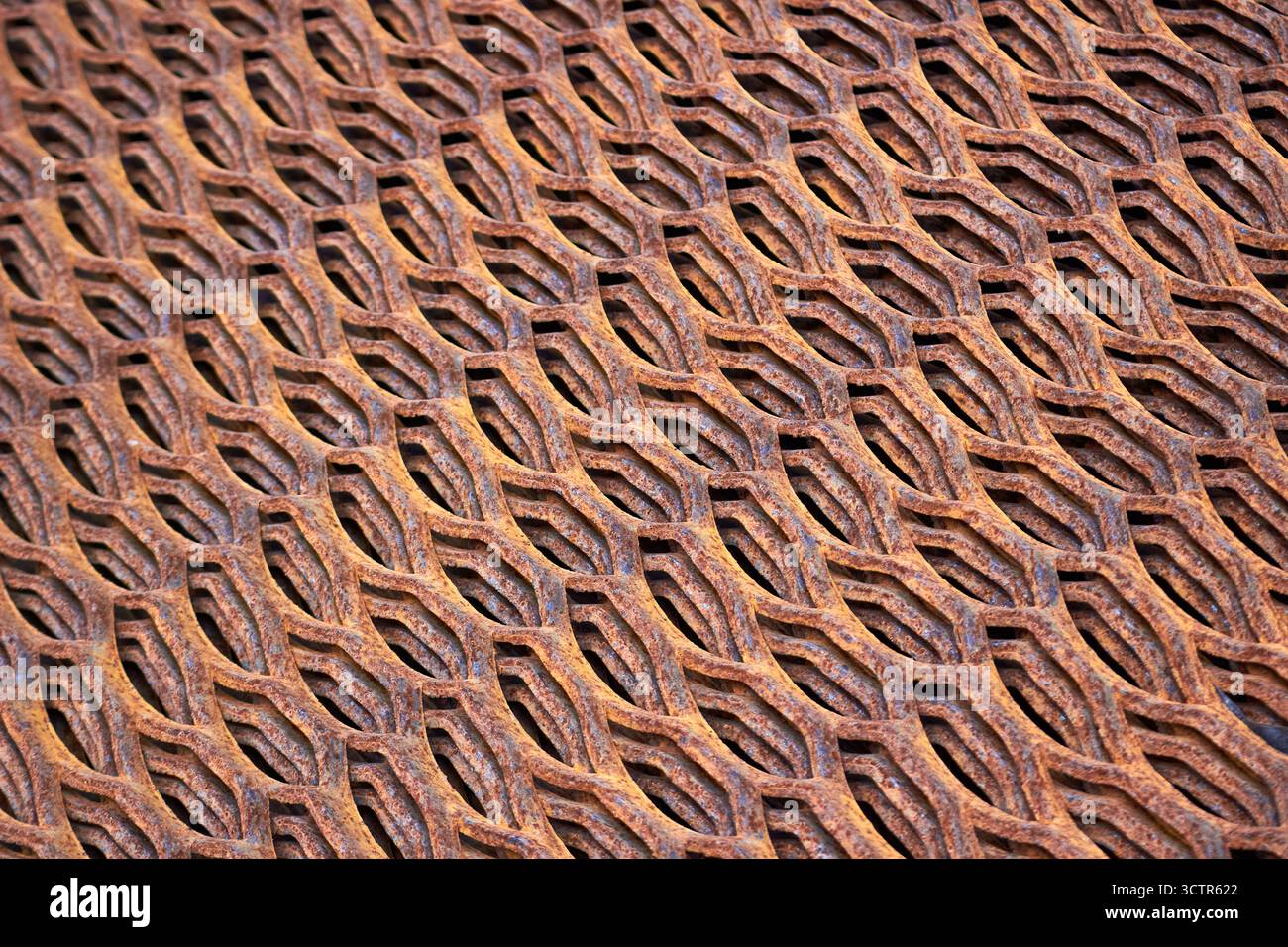 Perforiertes rostiges Metallbodenblech Stanzplatten Textur Großansicht gewinkelte Ansicht. Metallstanzen Blechherstellung Leichtlagerböden Stockfoto