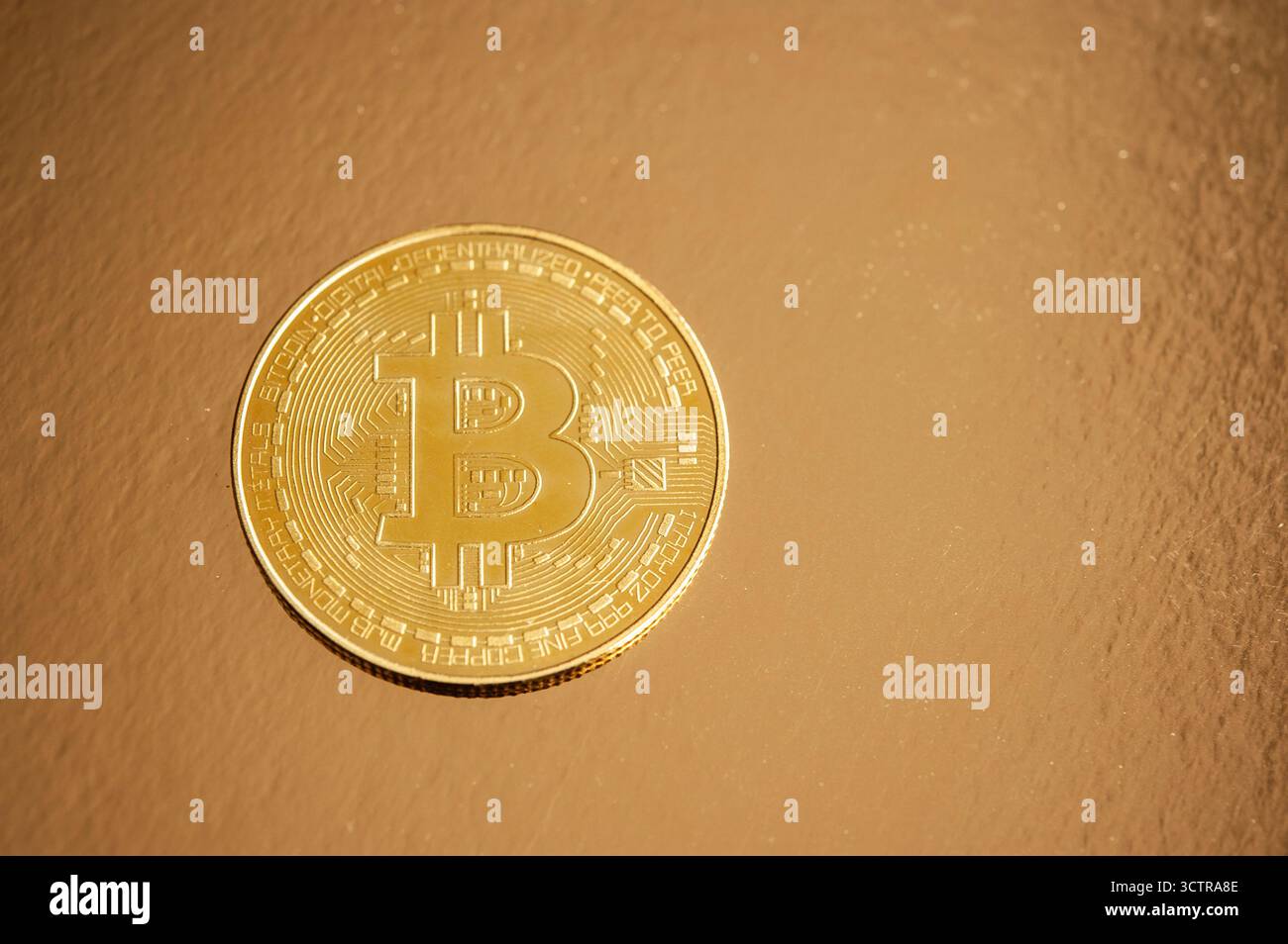Goldene Bitcoin-Münze auf einer reflektierenden Oberfläche, die digitalen Reichtum und virtuelle Währung symbolisiert Stockfoto