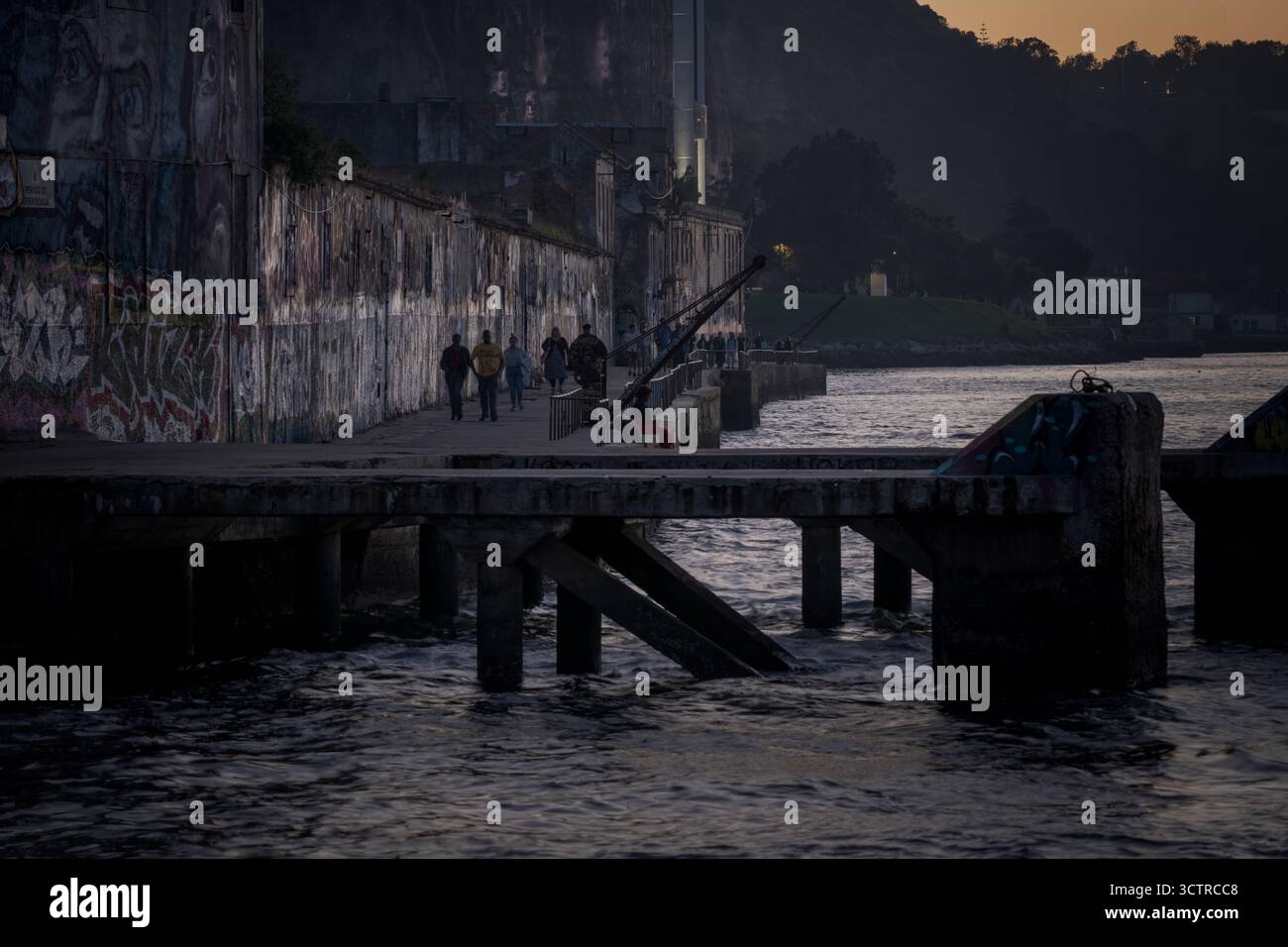 Urban Waterfront Promenade mit Street Art und Abendlicht – Graffiti Wall am Fluss in Moody City Atmosphäre Stockfoto
