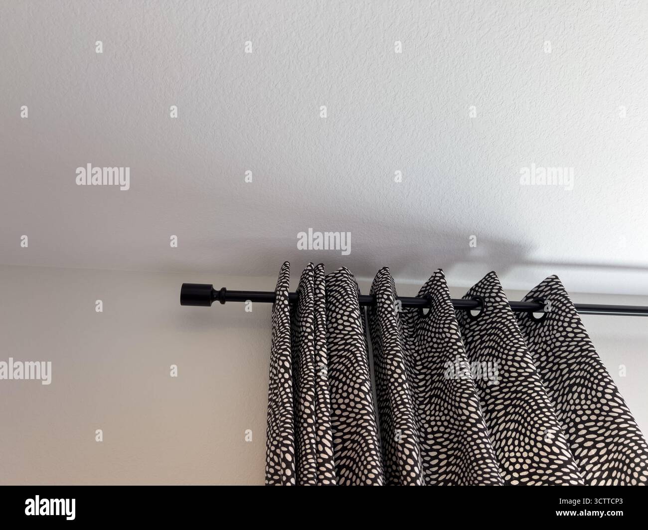 Schwarz-weiß gemusterte Vorhänge mit Rod Stockfoto