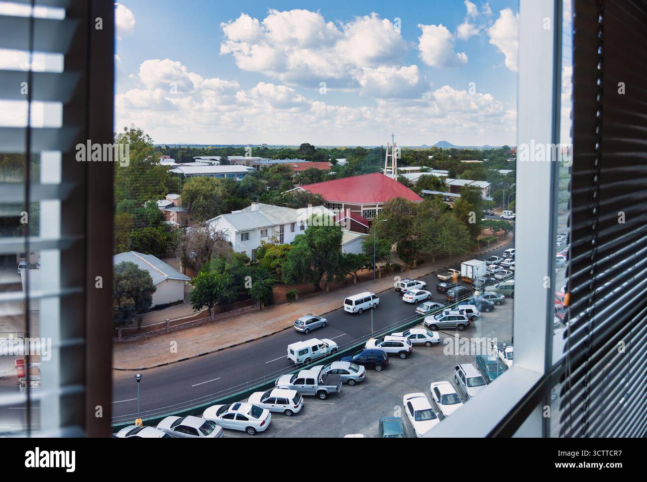 Blick auf die Straße in einem hohen Winkel durch das Fenster im obersten Stockwerk, Parkplatz und Straße, Blick auf die Stadt Gaborone, Botswana Stockfoto