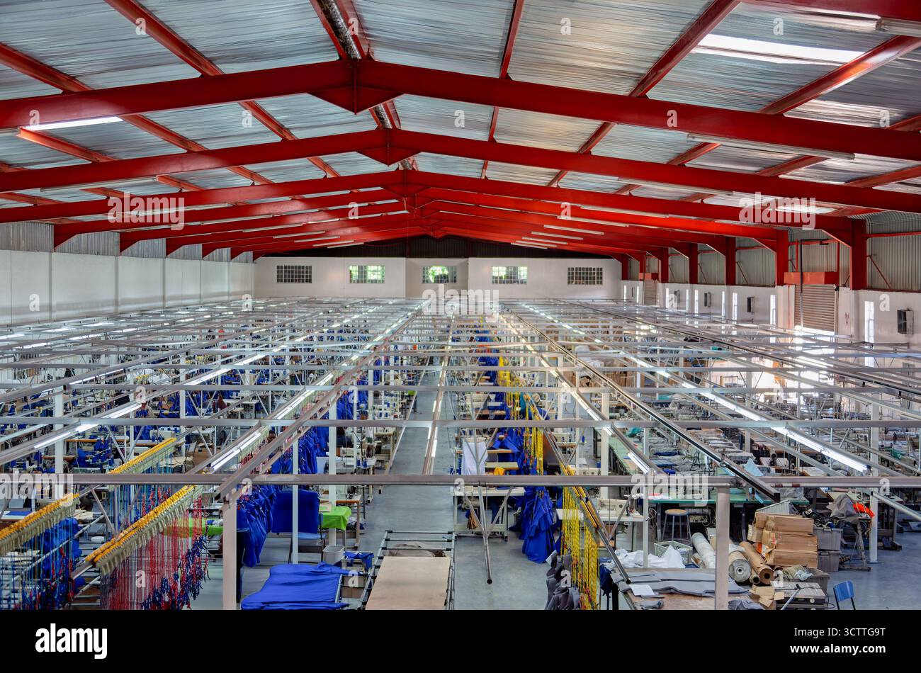 Textilfabrik Innenansicht von oben, Herstellung von Arbeitskleidung für den lokalen Markt, afrikanische Arbeitnehmerinnen in Nähmaschinen Stockfoto