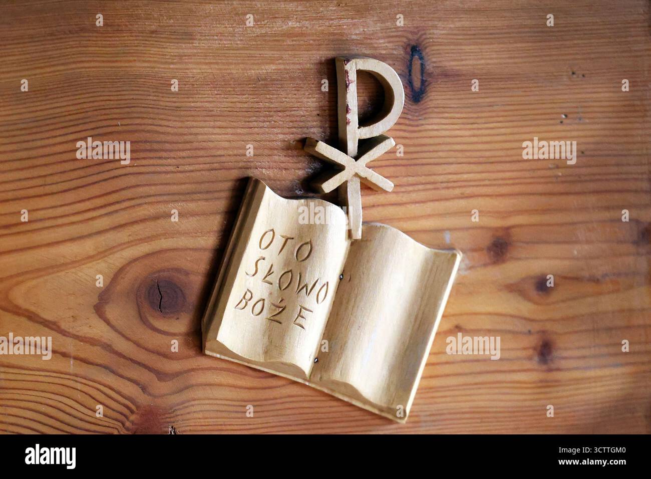 Christliche Holzskulptur mit einer offenen Bibel mit dem polnischen Text „das ist das Wort Gottes“ Stockfoto
