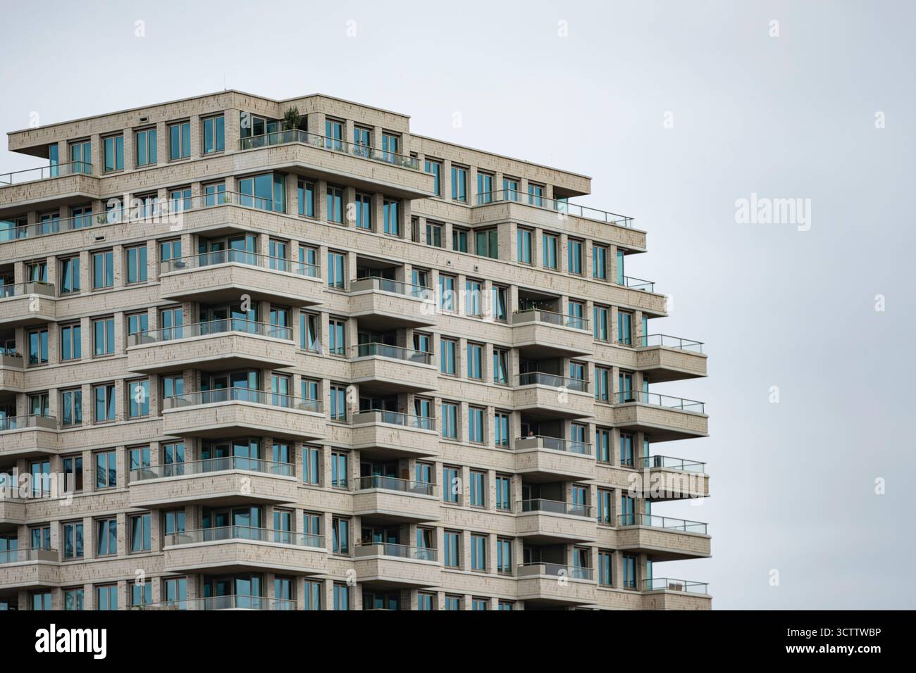 Modernes Hochhaus mit großen Balkonen vor grauem, bewölktem Himmel Stockfoto