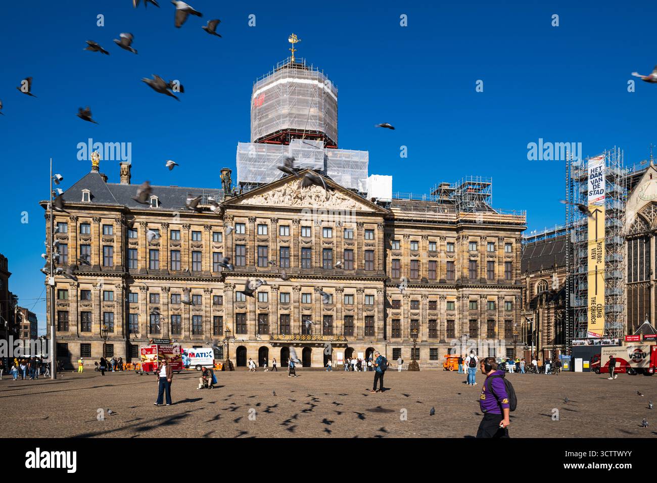 Amsterdam, Niederlande, 29. August 2025. Fassade des Königspalastes mit Gerüsten um die Kuppel während der Renovierung. Weitwinkelansicht, blauer Himmel und Stockfoto