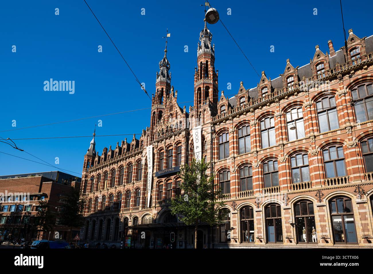 Amsterdam, Niederlande, 29. August 2025. Magna Plaza Einkaufszentrum, Außenansicht von der Vorderseite. Weitwinkel, sonniger Sommertag, blauer Himmel Stockfoto