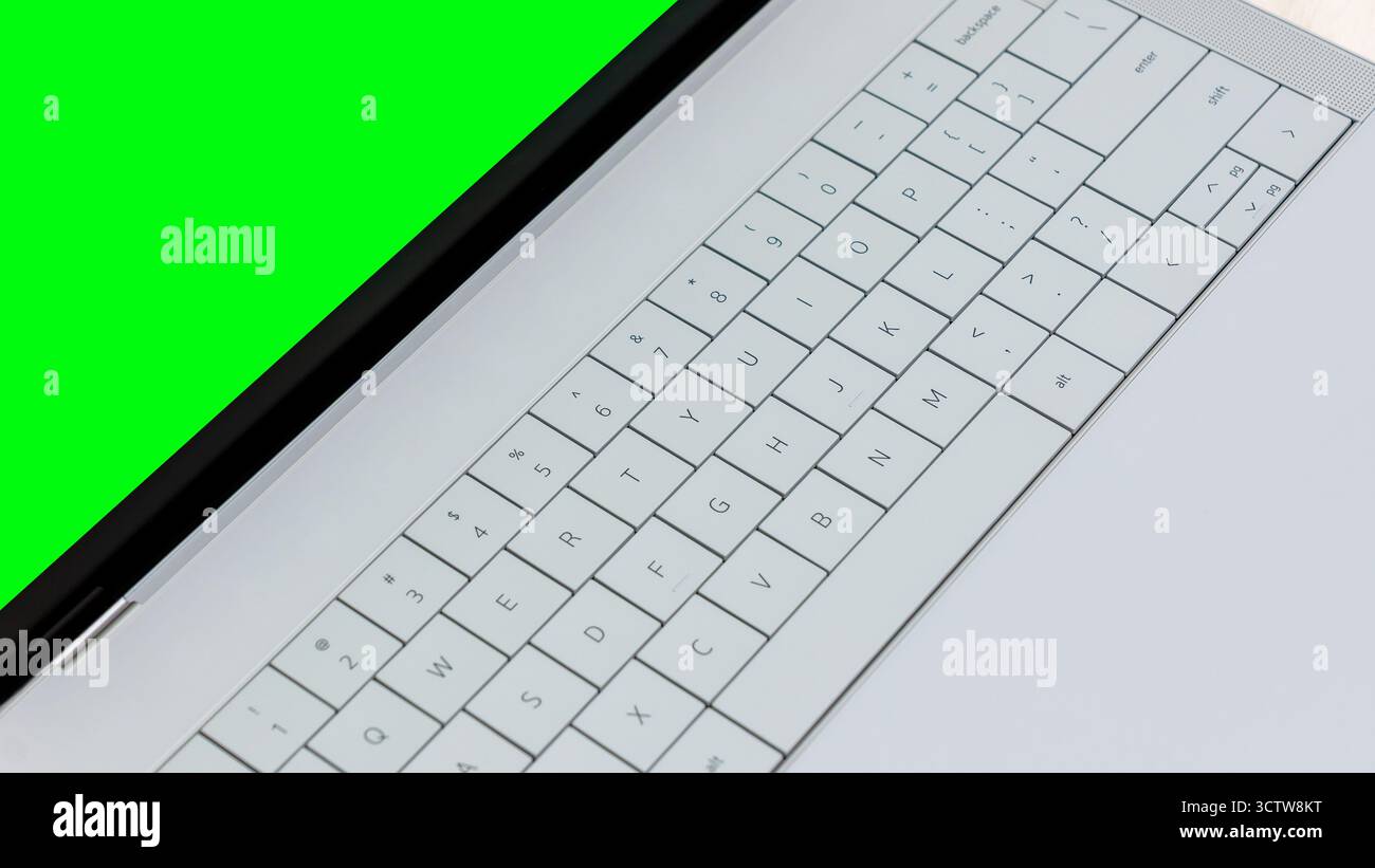 Das Notebook-Modell verfügt über ein lebhaftes grünes Display und eine moderne Tastatur, perfekt für Designer, die digitale Inhalte kreativ präsentieren möchten Stockfoto