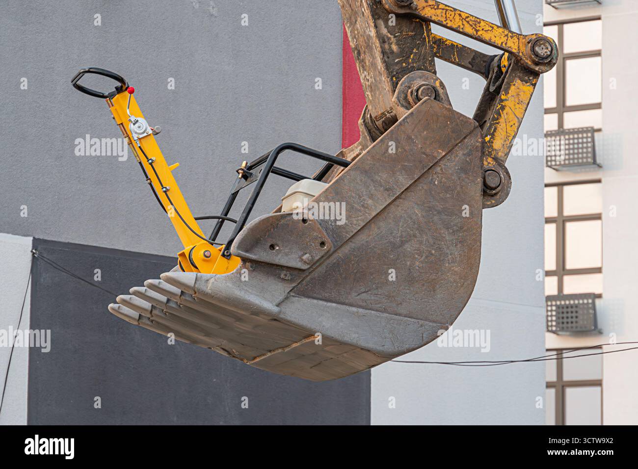 Das Bild zeigt einen Bagger in der Luft vor einem Baugrund, der den industriellen Fortschritt und den Einsatz schwerer Maschinen symbolisiert Stockfoto