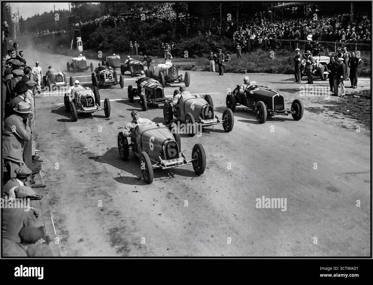 Der Start des Großen Preises von Belgien 1931 am 12. Juli 1931 auf der beeindruckenden Strecke von Spa-Francorchamps markierte die dritte und letzte Runde der ersten Europameisterschaft. Die Veranstaltung war als zermürbendes 10-Stunden-Ausdauerrennen im Team-Format mit zwei Fahrern strukturiert. In der Startaufstellung, die eher durch Stimmzettel als durch zeitgesteuertes Training festgelegt wurde, sicherte sich das dominante Alfa Corse-Team mit dem Alfa Romeo 8C-2300 von Ferdinando Minoia und Giovanni Minozzi die Pole-Position. Die Bugatti von William Grover-Williams und Caberto Conelli errangen schließlich den Sieg in der Mitte Nr. 4 Stockfoto