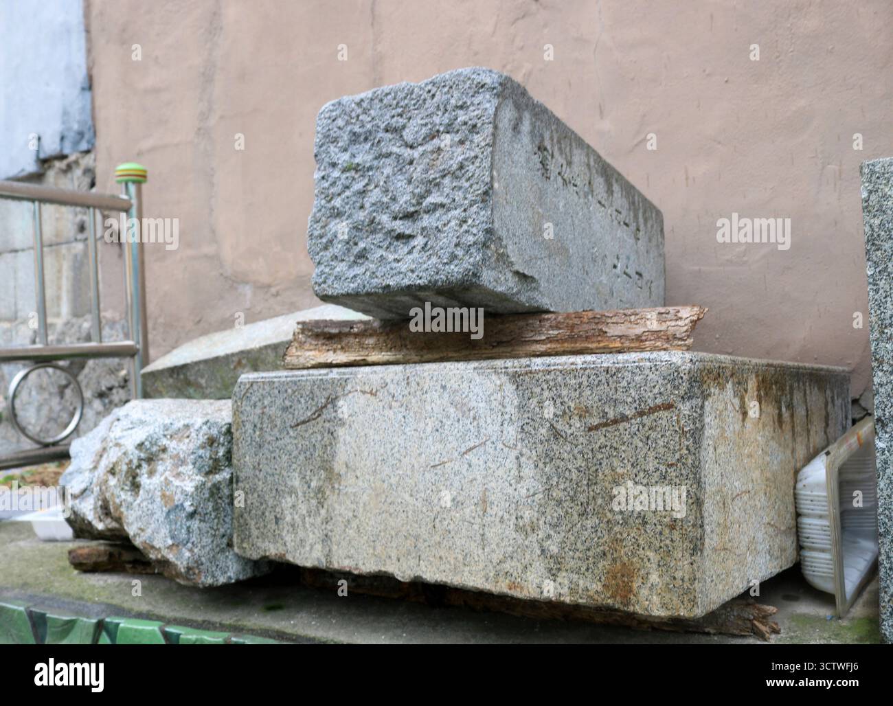 Ein Foto von wiederverwendbaren Grabsteinen im Ami-dong Tombstone Culture Village in der Nähe des Gamcheon Culture Village in Busan, Südkorea. Während des Koreakrieges begaben sich Flüchtlinge auf eine Reise mit nur einfachen Haushaltsgegenständen. Das Bergregion Ami-dong, ein ehemaliger japanischer Friedhof, wurde nach der Befreiung aufgegeben und nach und nach in ein Wohngebiet umgewandelt, als sich Flüchtlinge in Busan niederließen. In einer Zeit, in der die Baumaterialien spärlich waren, bauten die Menschen Häuser mit Dielen, Grabsteinen und Steinornamenten über Gräbern. 2025. Stockfoto