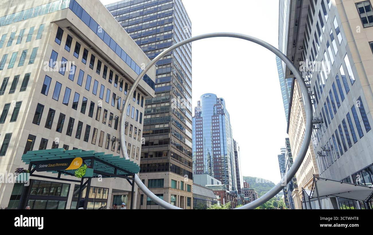 Montreal QC, Kanada - 20. Juli 2025: Die Ringskulptur am Place Ville Marie in Montreal, umrahmt von Wolkenkratzern, beleuchtet urbane Kunst und Architektur Stockfoto