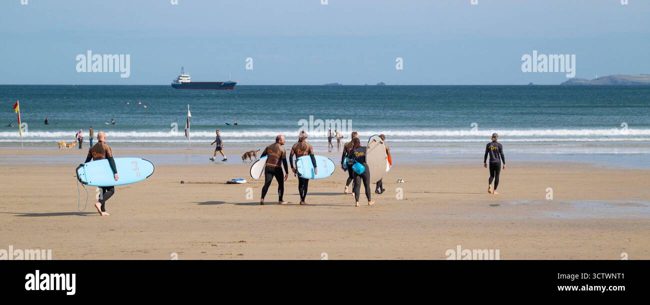 Ein Panoramabild einer Gruppe von Urlaubern, die an einer Surfstunde mit Lehrern der Cornish Wave Surf School am Towan Beach in Newquay in Corn teilnehmen Stockfoto