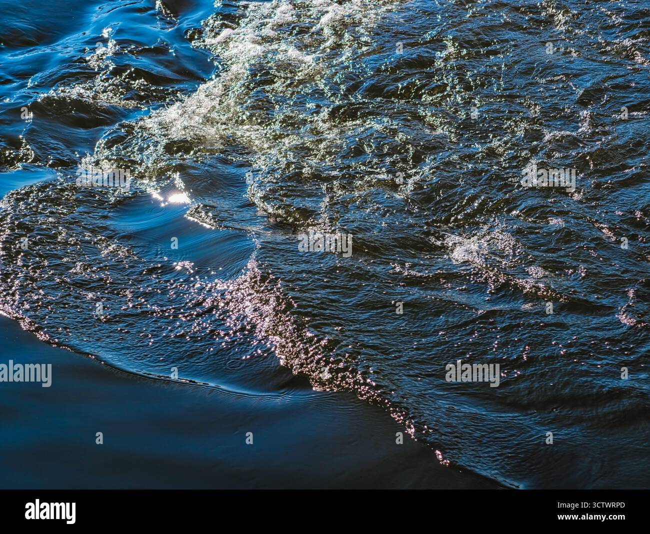 Glitzernde Ozeanwasseroberfläche mit Sonnenlichtreflektionen - abstrakte blaue Meereswellen-Textur für Natur und Meditationsinhalte. Ultrahohe Auflösung Stockfoto