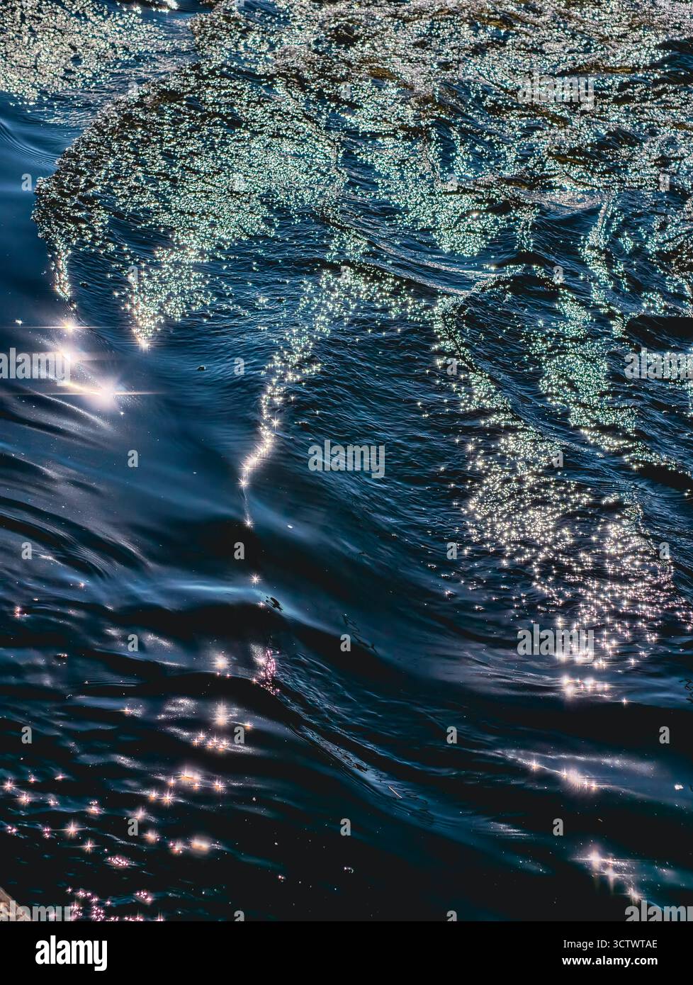 Funkelnde Ozeanwelle mit Sonnenlichtreflektionen - tiefblaue Meerwasser-Oberflächenstruktur für Natur- und Meditationshintergrund-Design Stockfoto