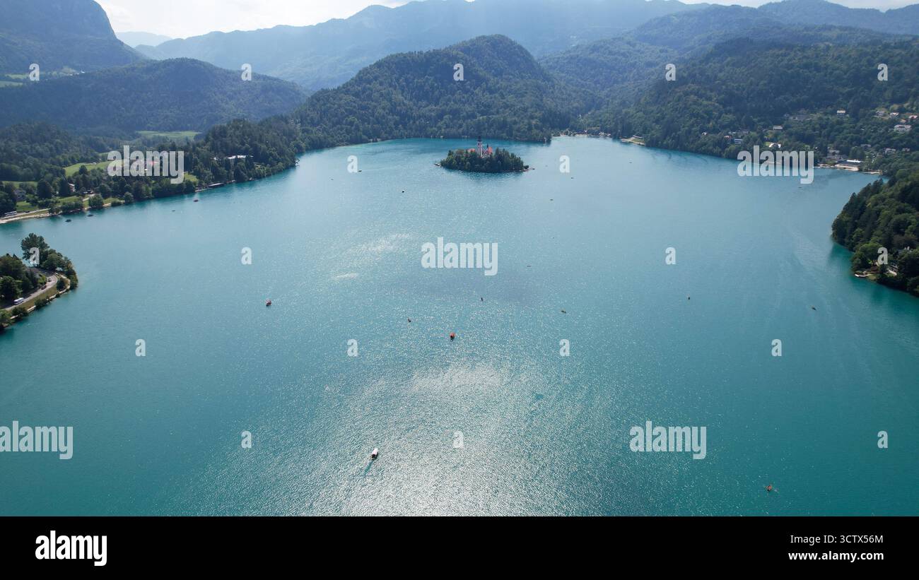 Drohnenaufnahme auf Lake Bled Island, umgeben von Bergen und Wäldern Stockfoto