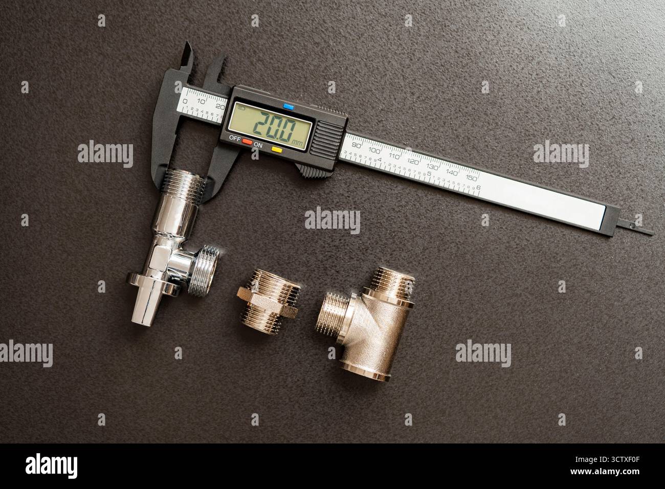 Messung des Durchmessers von Rohrleitungsadaptern mit einem elektronischen digitalen Messschieber, Nahaufnahme, Draufsicht. Sanierungskonzept für Sanitär Stockfoto