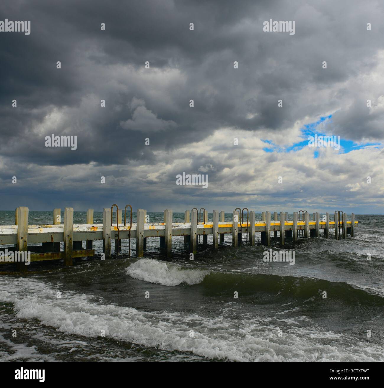 Brighton Australia Pier und Bootsrampe in stürmischem Himmel und stürzenden Wellen Stockfoto