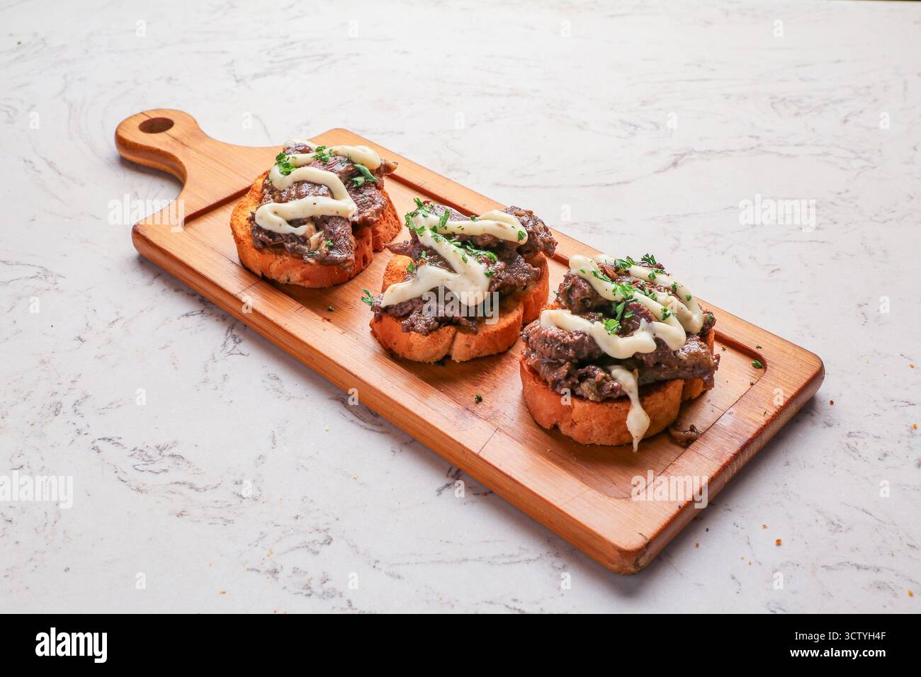 Geröstetes Rindfleisch-Crostini-Baguette, Steakscheiben, karamelisierte Zwiebeln und Pilze, Blaukäse Stockfoto