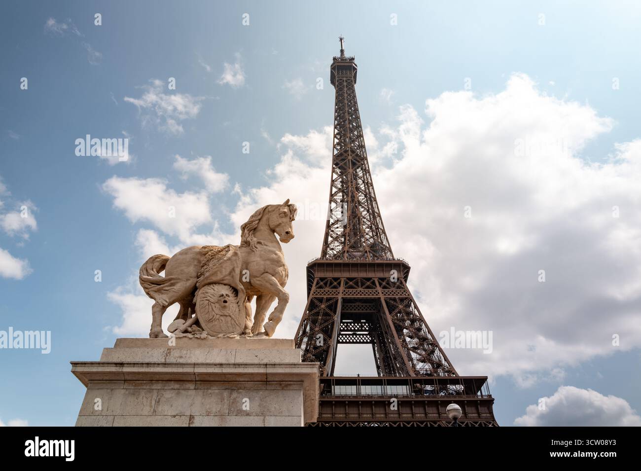 Eiffelturm mit einer Pferdestatue unter einem hellen Himmel in Paris, Frankreich, zeigt ikonische Architektur und Kultur. Stockfoto