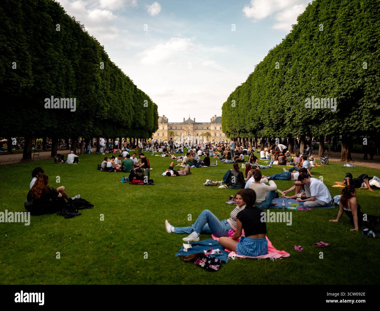 An einem sonnigen Nachmittag entspannen und sich auf dem Rasen in den Jardin du Luxembourg in Paris treffen. Stockfoto