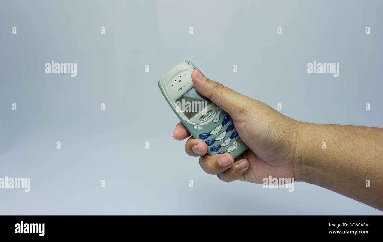 Südkalimantan, Indonesien - 07 30 2024 : Nokia 3310 wird in der Hand gehalten, isoliert auf weißem Hintergrund Stockfoto