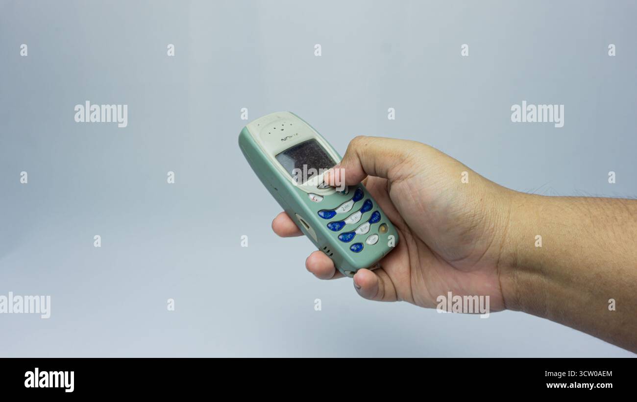 Südkalimantan, Indonesien - 07 30 2024 : Nokia 3310 wird in der Hand gehalten, isoliert auf weißem Hintergrund Stockfoto