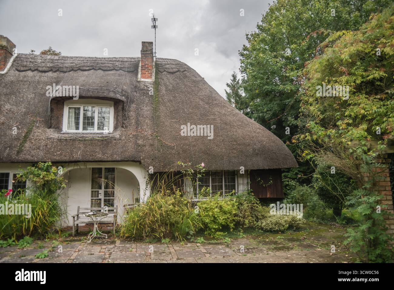 Traditionelles englisches Strohhaus umgeben von Gartengrün. Stockfoto