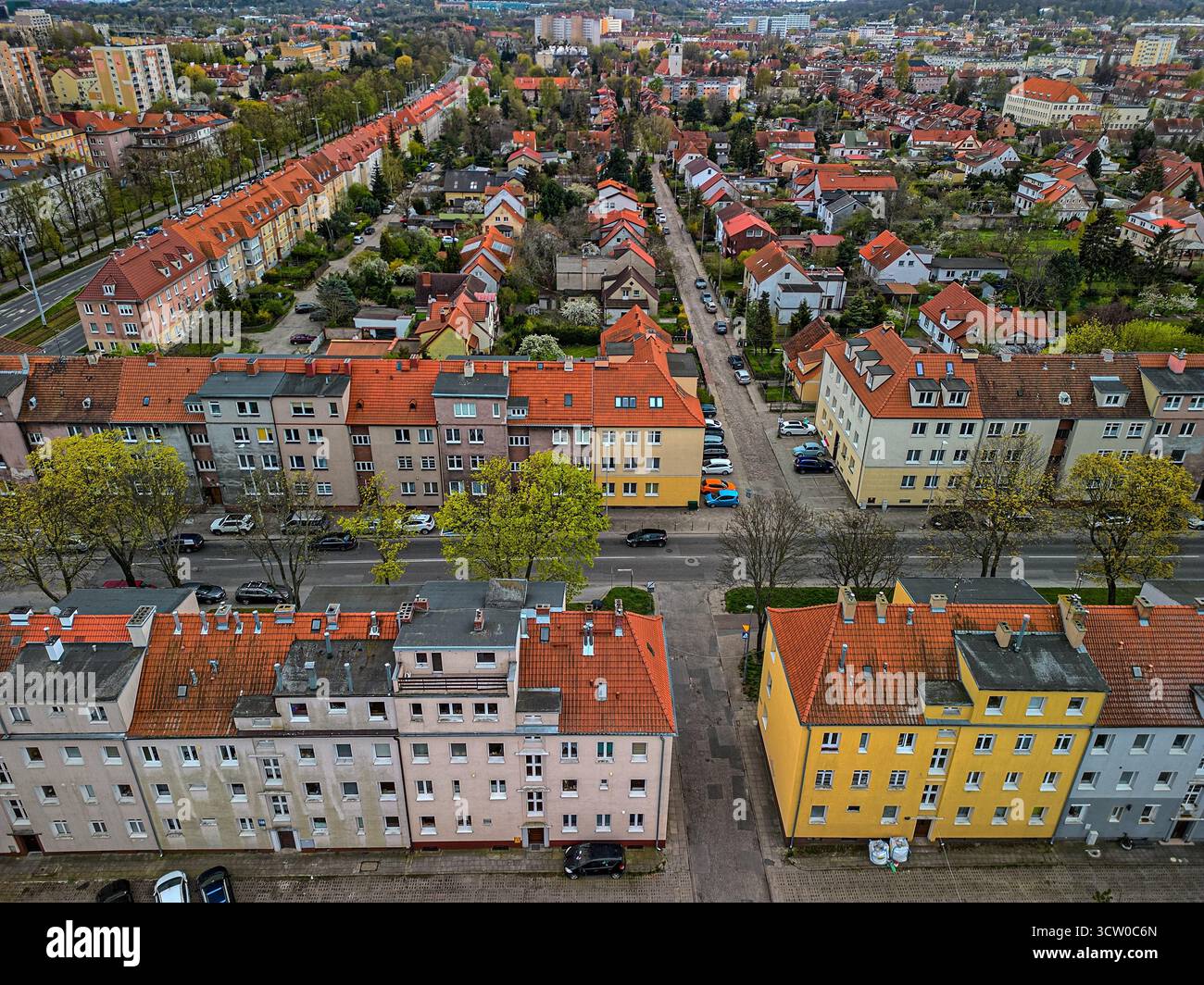 Vielfältige Luftaufnahmen von Wohnvierteln mit farbenfrohen Gebäuden, roten Ziegeldächern und Grünflächen, die europäische Stadtarchitektur zeigen Stockfoto