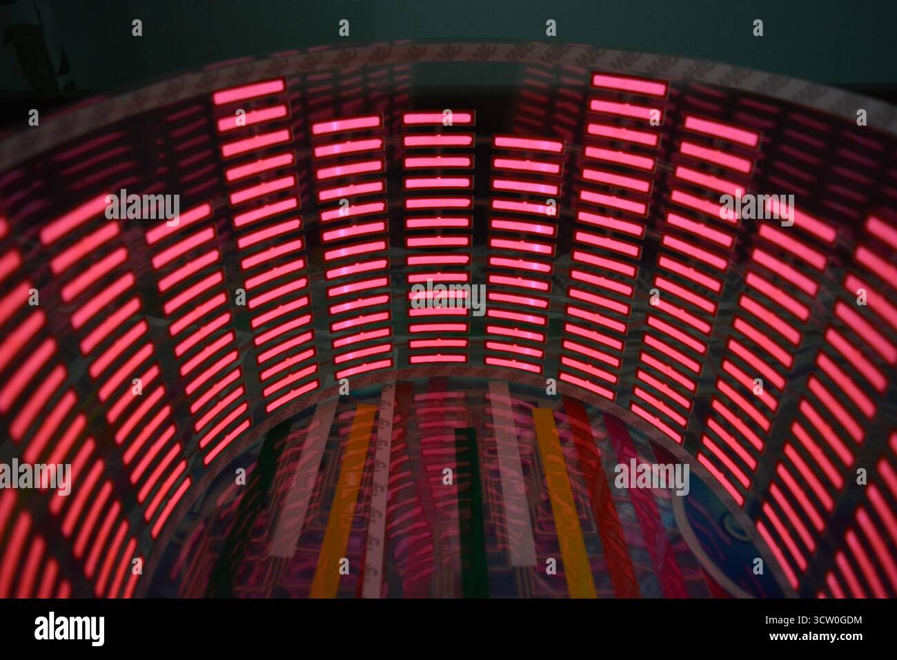 Roter, leuchtender Plastikaufkleber in Form eines echten Equalizers, der zur Musik aufblitzt. Viele rot leuchtende Quadrate auf weichem Kunststoffhintergrund, lebhaft, Stockfoto