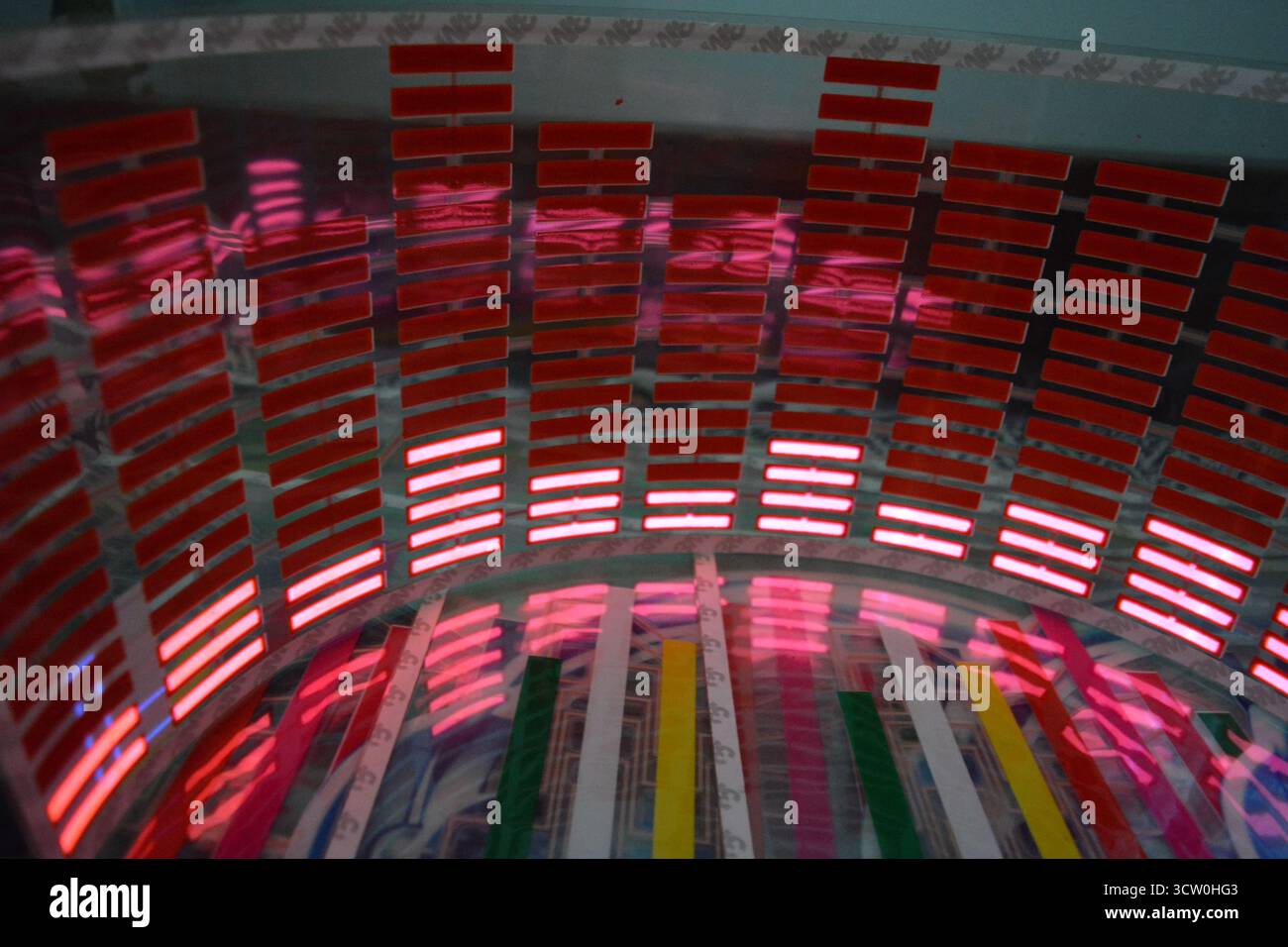 Roter, leuchtender Plastikaufkleber in Form eines echten Equalizers, der zur Musik aufblitzt. Viele rot leuchtende Quadrate auf weichem Kunststoffhintergrund, lebhaft, Stockfoto