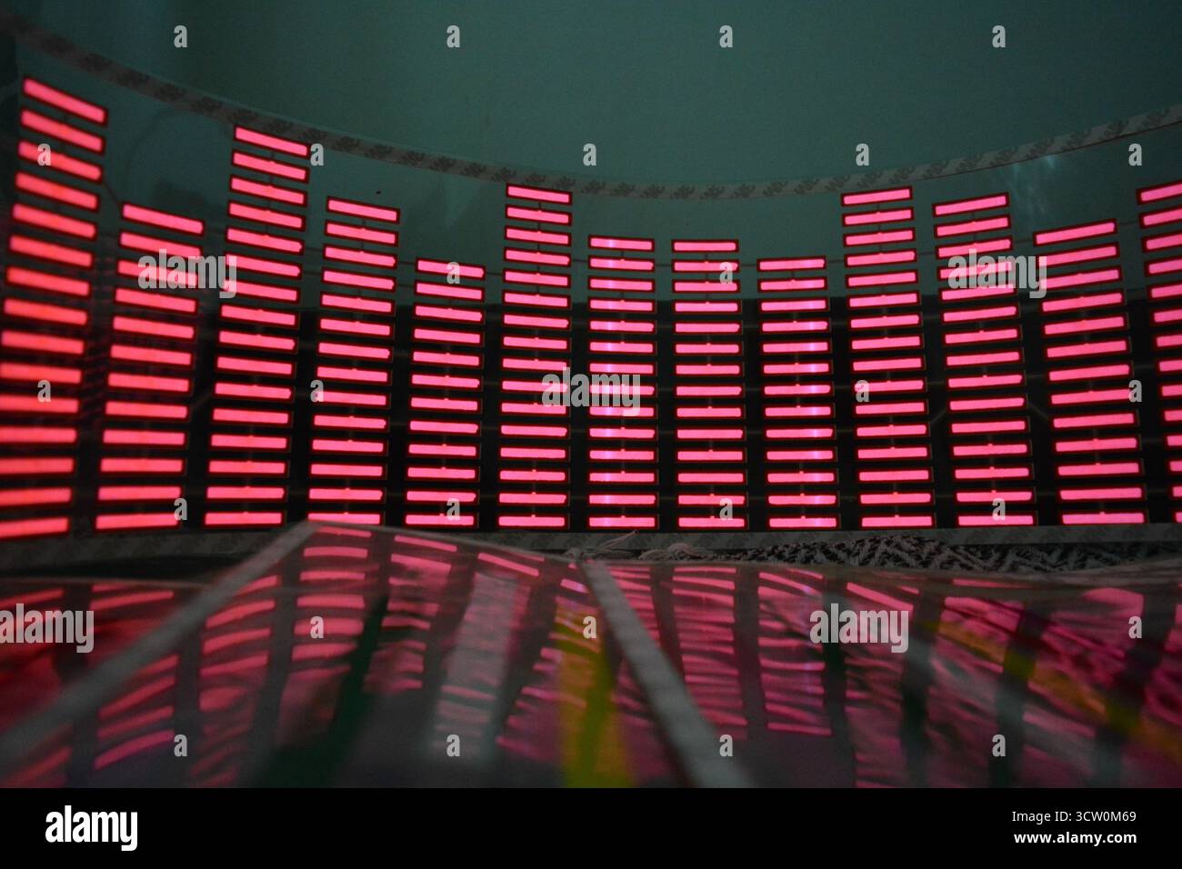 Roter, leuchtender Plastikaufkleber in Form eines echten Equalizers, der zur Musik aufblitzt. Viele rot leuchtende Quadrate auf weichem Kunststoffhintergrund, lebhaft, Stockfoto