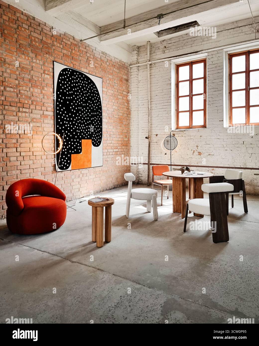 Loft-Innenraum - alte leere Fabrik. Wohnzimmer mit zufällig platzierten Plüschmöbeln wie Stühlen und Tisch. Stockfoto