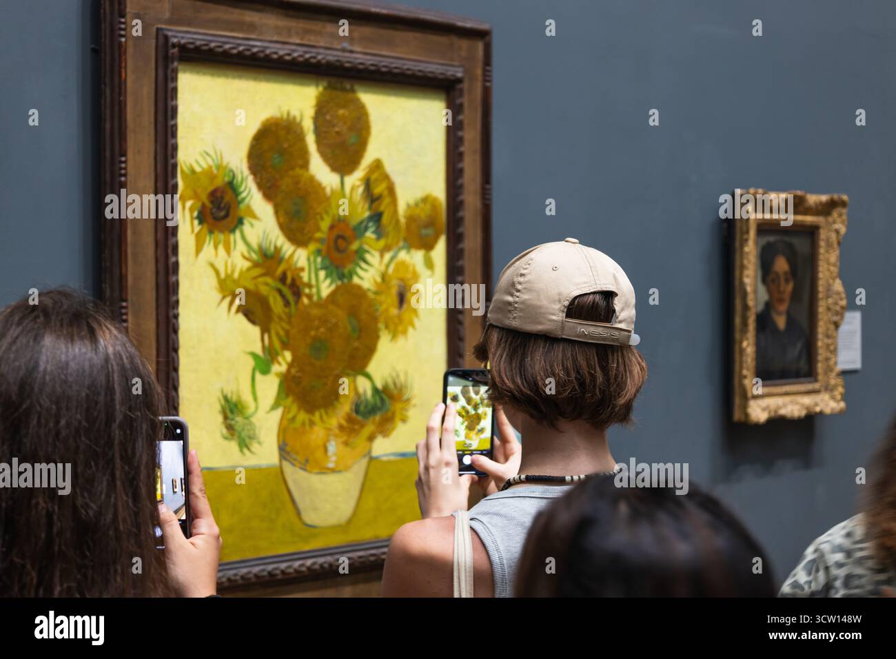 Touristen fotografieren Van Goghs Sonnenblumen in der National Gallery. London, UK, 28. Juni 2023 Stockfoto