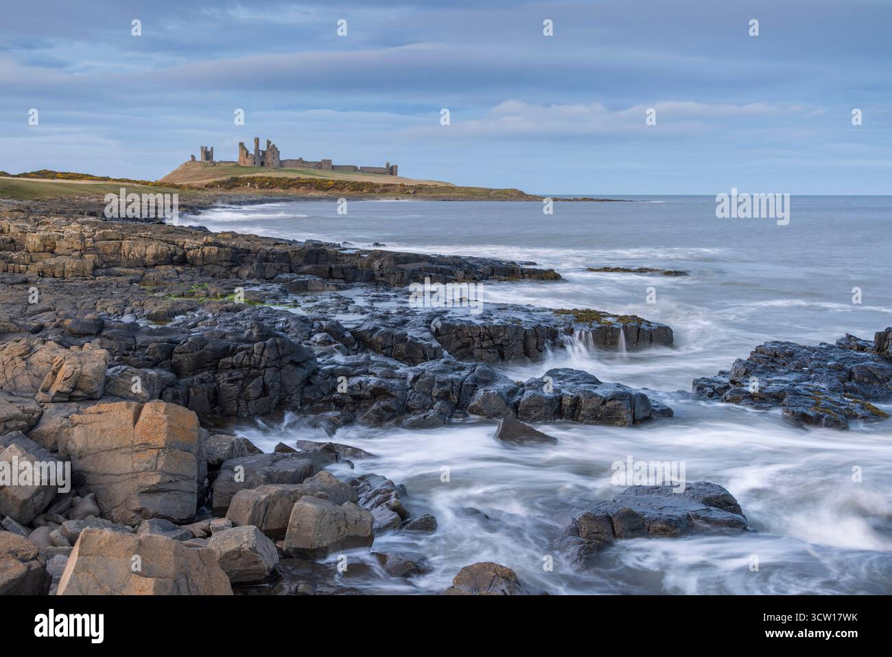 Dunstanburgh Castle oberhalb der felsigen Küste bei Craster, Northumberland, England. Winter (März) 2025. Stockfoto