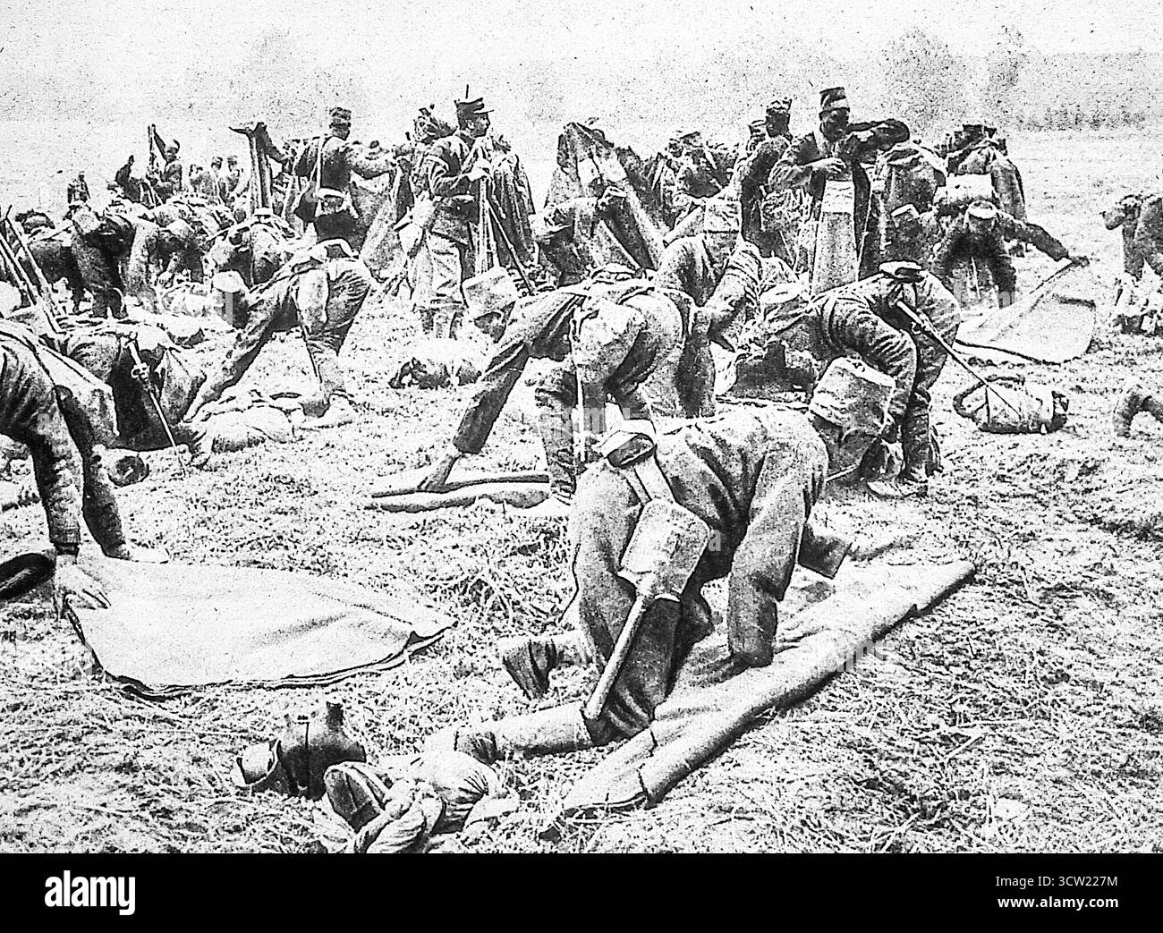 1916 Foto von Le Miroir von senegalesischen Tirailleurs, die Ausrüstung und Ausrüstung im Lager vor dem Marsch an die Front des Ersten Weltkriegs einlegten. Diese westafrikanischen Truppen, darunter Bambara, Oulof, Kassonk und Mandja Rekruten, waren für die Stärkung der französischen Stärke von entscheidender Bedeutung. Das Bild zeigt Soldaten, die sich in disziplinierter Vorbereitung über ihre Kits gebeugt haben, was den entscheidenden Beitrag der Kolonialeinheiten im zermürbenden europäischen Konflikt widerspiegelt. Stockfoto